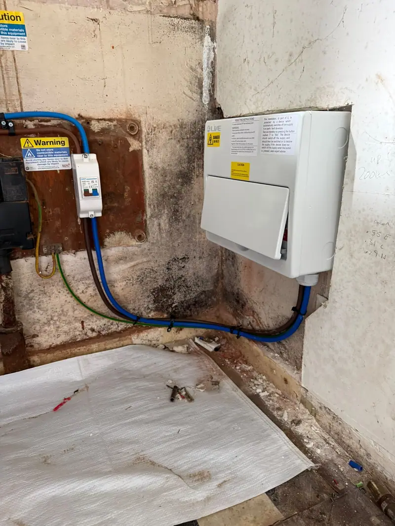 The finished metal consumer unit closed up on the cellar wall
