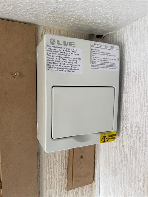 The replacement consumer unit closed up in the same position, with the RCD test notice on the front.