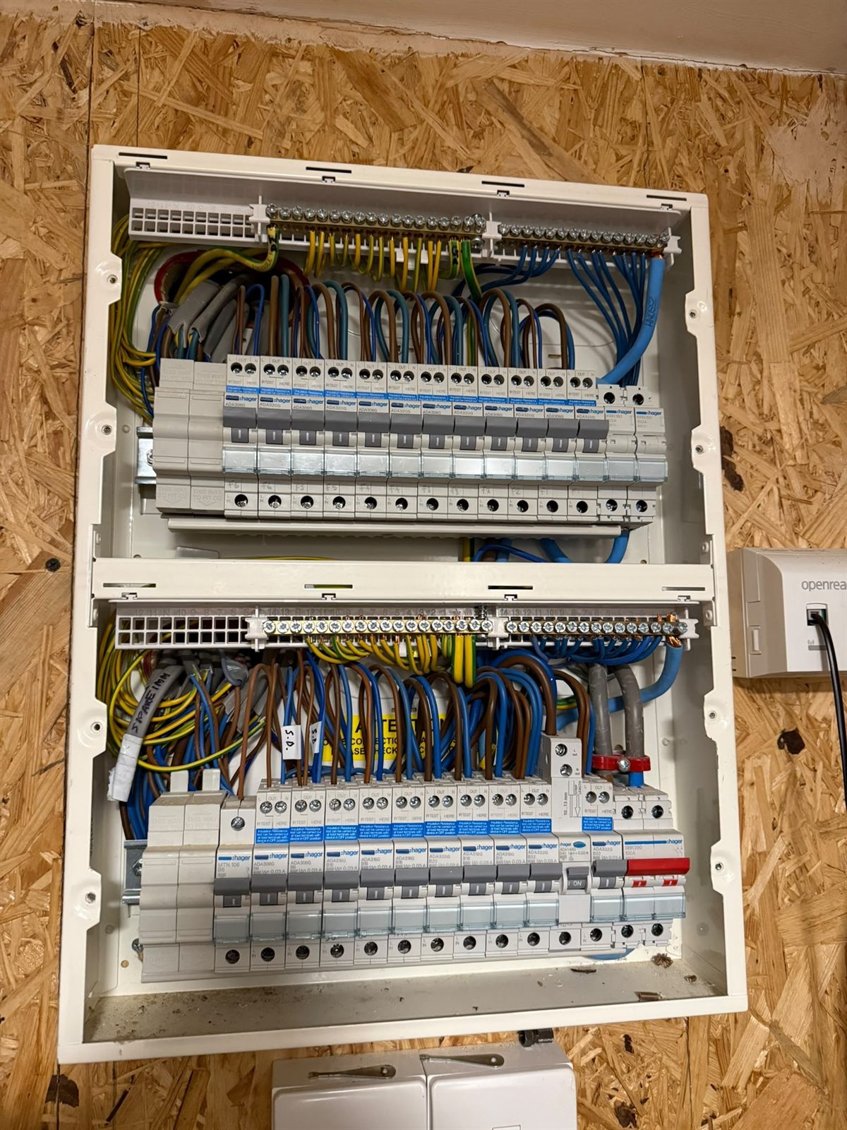 Two consumer units mounted one above the other, each way on its own RCBO, with the circuit conductors looped in and dressed neatly to the terminal bars.